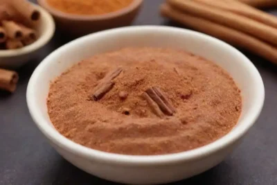 Un tazón de platos veganos vibrantes adornados con palos de canela y canela en polvo.