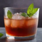 Té de monarda recién hecho servido en un vaso con hojas de menta y hielo.