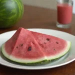 Sliced sandía en un plato junto a un gráfico de entrada recomendado diario.