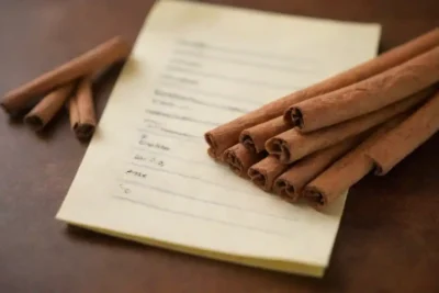 Unos pocos palos de canela junto a una lista de posibles efectos secundarios en un notepad.