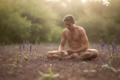 Imagen de una figura meditando rodeado de hojas de salvia y un entorno tranquilo.
