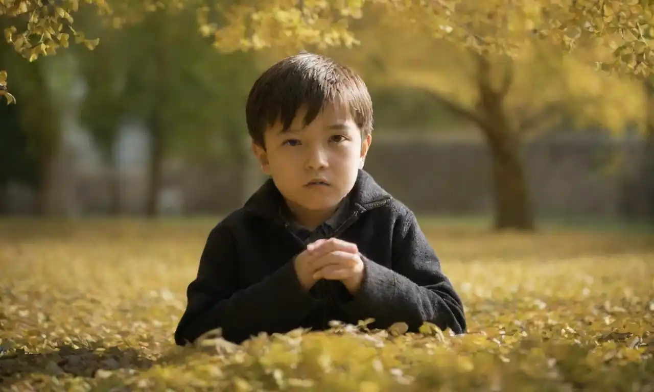 Un niño pequeño junto a hojas de ginkgo biloba en un entorno natural.