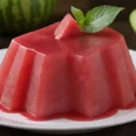 Un vibrante postre de gelatina de sandía adornado con rebanadas de sandía fresca.