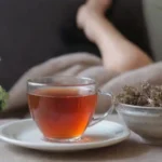 Una persona que se relaja con el té de raíz valeriana en un entorno tranquilo.
