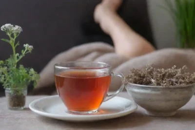 Una persona que se relaja con el té de raíz valeriana en un entorno tranquilo.