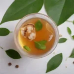 Copa de infusión de Pimpinela con hojas frescas e iconos relacionados con la salud que la rodean.
