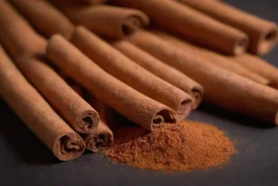 Productos de belleza fusionados con canelas dispuestos junto con palos de canela frescas y piel.