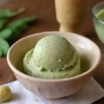 Tazón colorido de helado de moringa con ingredientes frescos y una tarjeta de receta a su lado.