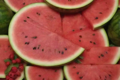 Una rebanada de sandía rodeada de frutas vibrantes