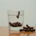 Ropas dispuestas junto a un vaso de agua y un icono de aliento fresco.