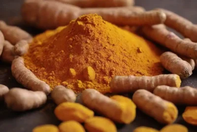 Cierre de raíces cúrcumas y polvo con etiquetas destacando sus beneficios antioxidantes.