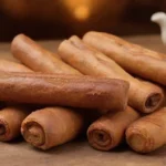 Pegatinas de canela y pastas bellamente dispuestas en una mesa de madera.