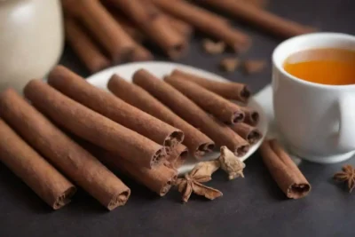 Pegatinas de canela y hojas secas junto a una taza de té herbal e iconos de salud.
